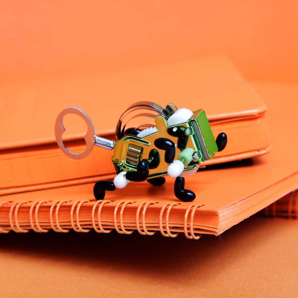 Metal wind-up toy in an orange scene